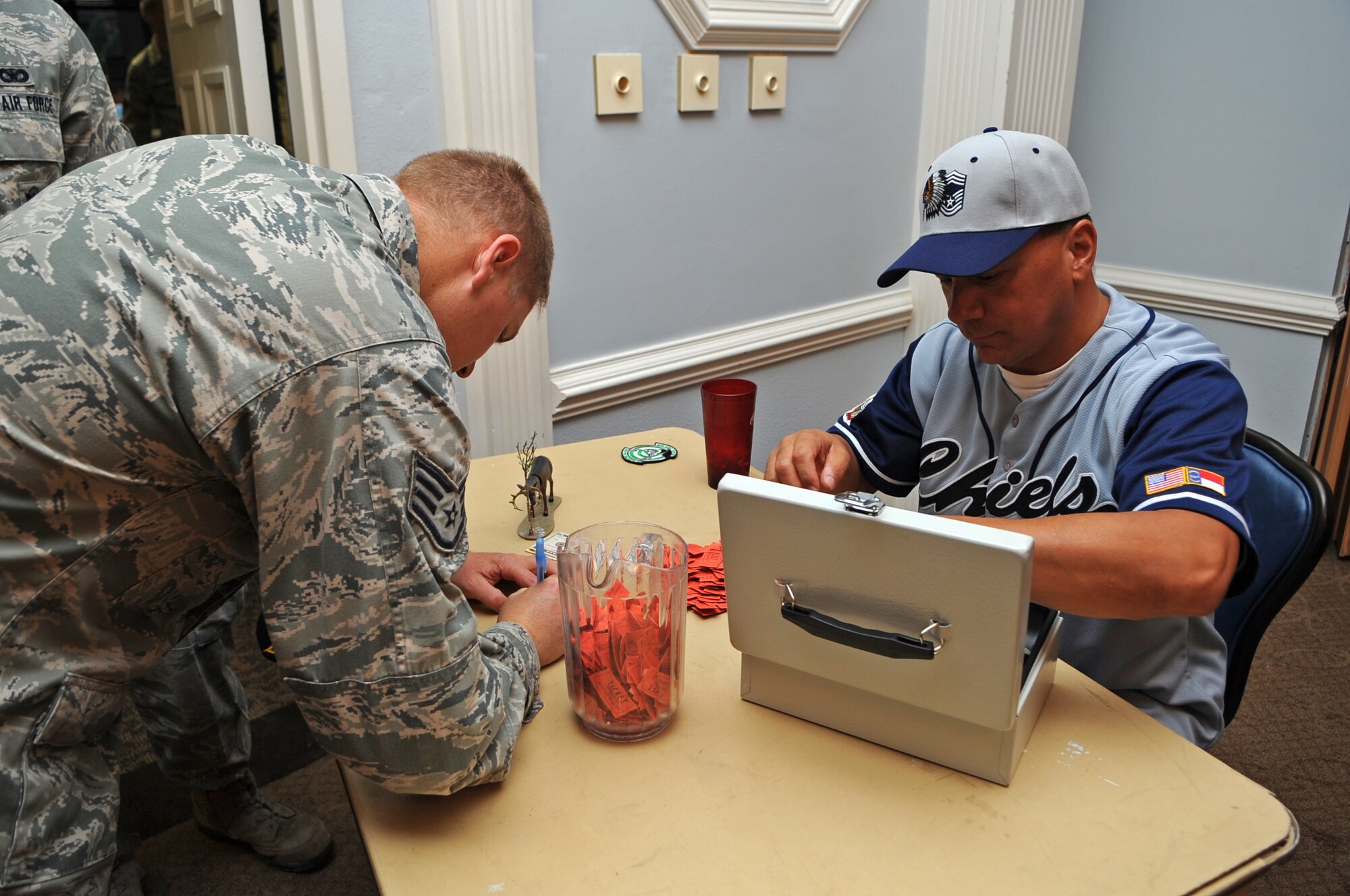 U.S. Air Force Chief Master Sgt. Jay Mason, 4th Maintenance Group wing weapons manager, sells a ticket to Staff Sgt. Tommy Dailey, 4th Security Forces Squadron combat arms instructor, during a Chief’s Group pancake breakfast on Seymour Johnson Air Force Base, N.C., Aug. 10, 2012. Proceeds from tickets sales will be used to support various wing and awards morale programs. (U.S. Air Force photo/Airman 1st Class Aubrey Robinson/Released)