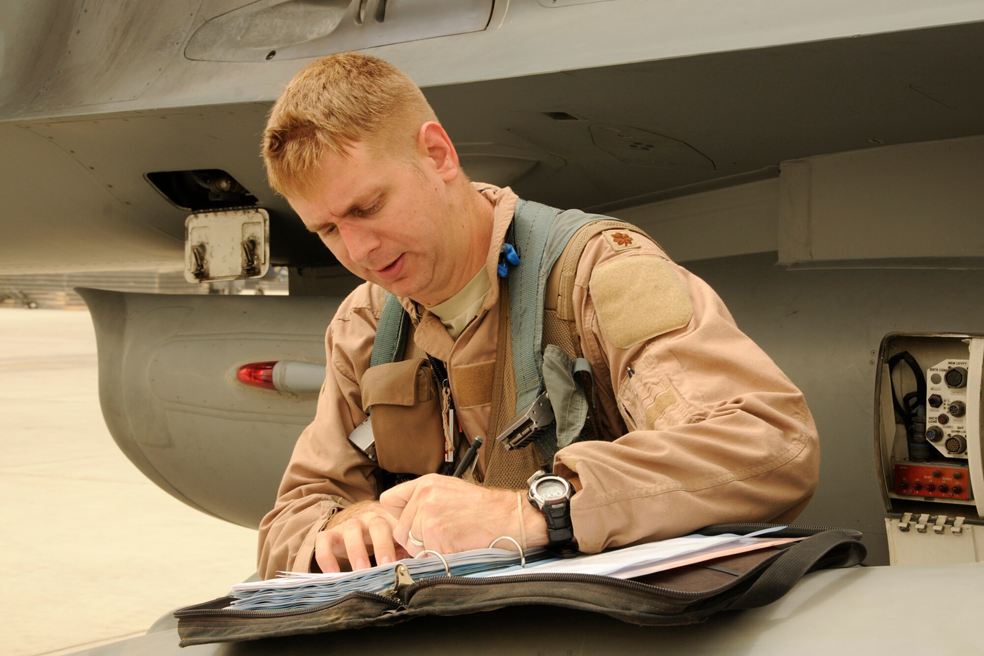 South Carolina Air National Guard Maj. Ian "Chester" Toogood, an F-16 pilot, completes paperwork after returning from a mission over Afghanistan on Aug. 5, 2012. Members of the 169th Fighter Wing at McEntire Joint National Guard Base, S.C., are deployed to KAF in support of Operation Enduring Freedom. Swamp Fox F-16's, pilots, and support personnel began their Air Expeditionary Force deployment early April to take over flying missions for the air tasking order and provide close air support for troops on the ground in Afghanistan. (U.S. Air Force photo/Tech. Sgt. Stephen Hudson)
