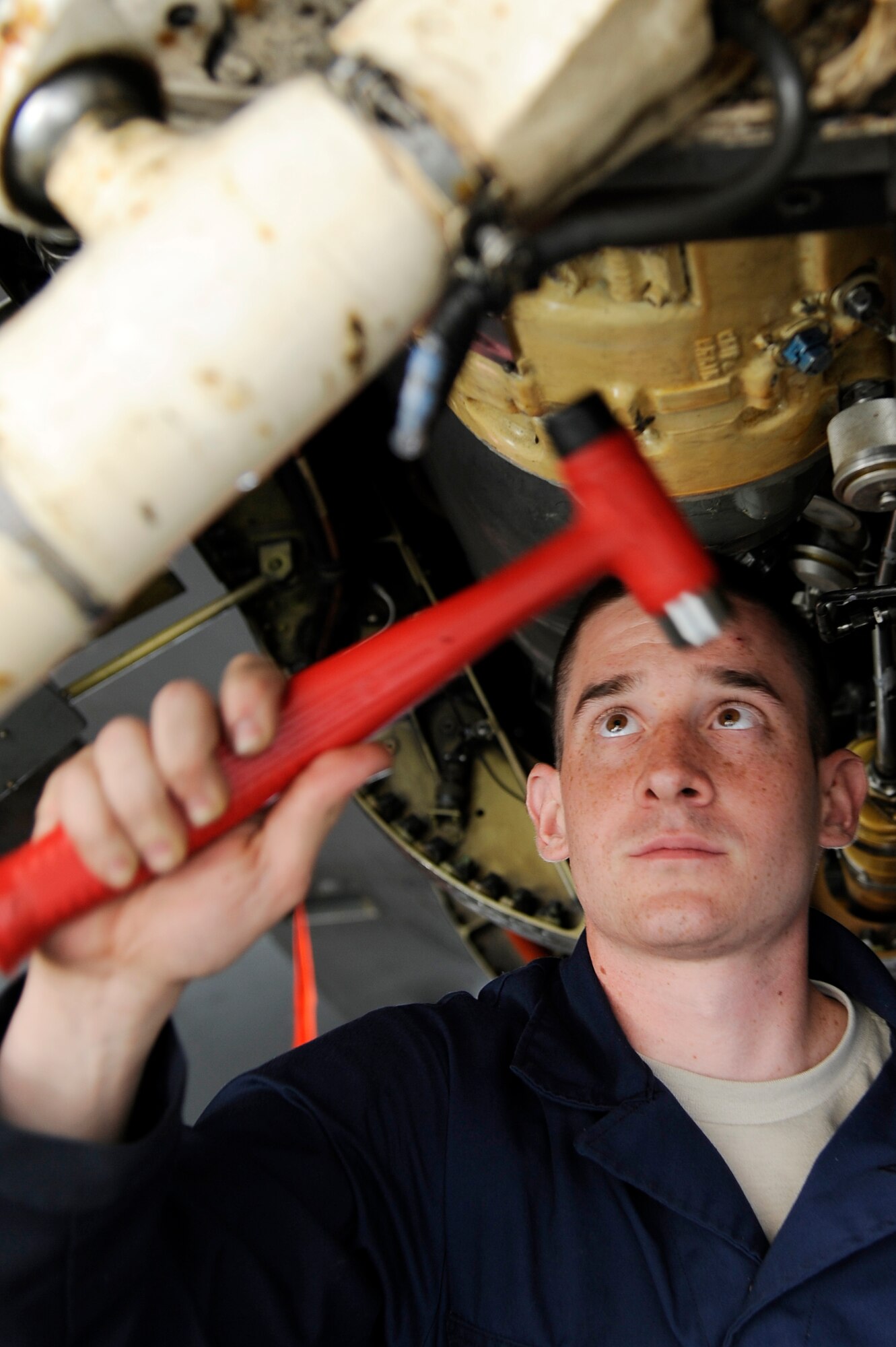 U.S. Air Force Airman 1st Class Richard Neal, 13th Aircraft Maintenance Unit electrical and environmental specialist from Misawa Air Base, Japan, hammers a clamp onto an F-16 Fighting Falcon during RED FLAG-Alaska 12-3 Aug. 10, 2012, Eielson Air Force Base, Alaska.  (U.S. Air Force photo/Staff Sgt. Jim Araos)