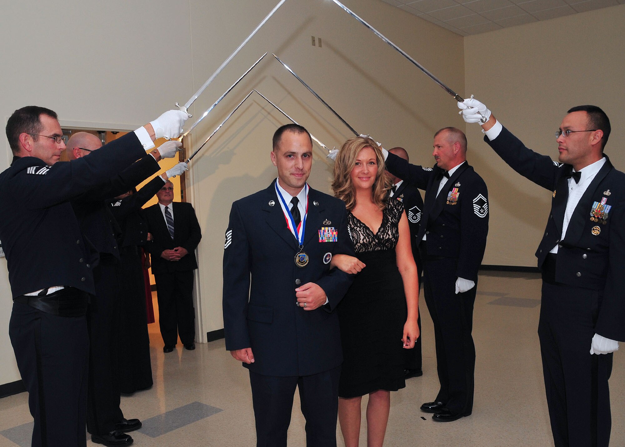 Tech. Sgt. Kevin Perusich, 373rd Training Squadron Det. 13, along with his wife Andrea O'Brien-Perusich pass under the saber cordon July 27, 2012 at the Armed Forces Reserve Center during the Senior NCO Induction ceremony. Perusich and his new bride married less than an hour before the ceremony kicked off in downtown Spokane. The newlyweds still made it to the voluntary ceremony on time exemplifying the Air Force’s second core value -- service before self. (U.S. Air Force photo by Airman 1st Class Earlandez Young)