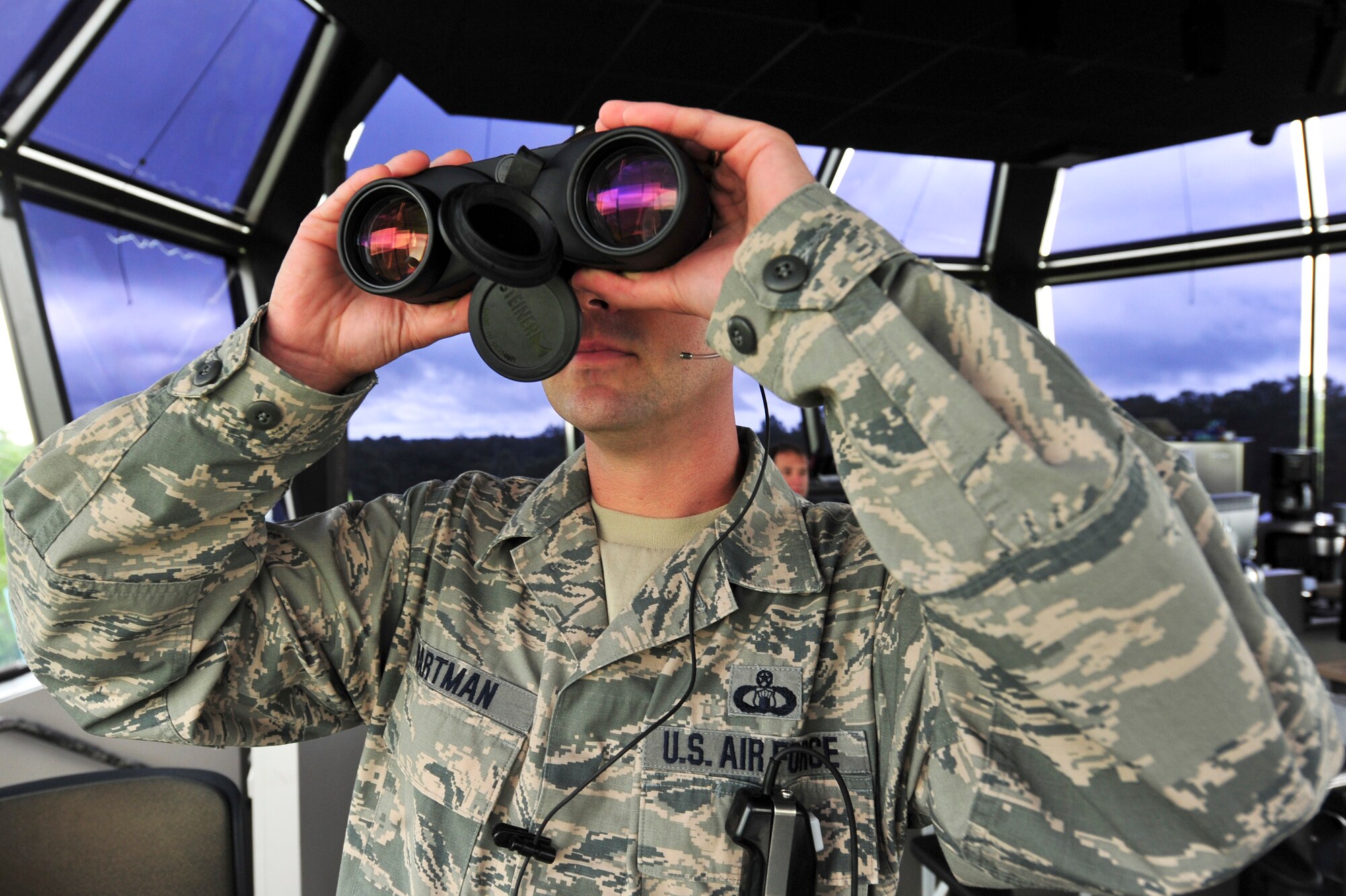U.S. Air Force Master Sgt. Justin Hartman, 23rd Operations Support Squadron assistant chief controller for the tower, uses binoculars to check landing aircraft at Moody Air Force Base, Ga., Aug. 12, 2012. Binoculars are used to ensure the aircraft's landing gear is working properly. Due to his leadership traits, Hartman won the Lance P. Sijan award for the Air Combat Command.  (U.S. Air Force photo by Staff Sgt. Joshua J. Garcia/Released)
