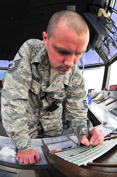 U.S. Air Force Master Sgt. Justin Hartman, 23d Operations Support Squadron assistant chief controller for the tower, updates a flight progress strip at Moody Air Force Base, Ga., Aug. 12, 2012. The strip is used to keep air traffic controllers updated on each aircraft that departs from the base. Air Combat Command awarded Hartman the Lance P. Sijan award for his leadership capabilities on and off duty. (U.S. Air Force photo by Staff Sgt. Joshua J. Garcia/Released)