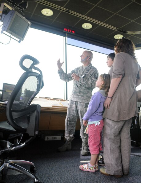 RAF MILDENHALL, England -- Master Sgt. Markus Fuehrmann, 100th Operations Support Squadron, explains air traffic control procedures to the Ewing family Aug. 10, 2012. Tragedy struck the family in 2008, when Ministry of Defence Police Sergeant Jimmy Ewing died of a heart attack, leaving his wife Isobel to raise their two young children, Callum and Denna, who were 8 and 2 respectively at the time. A family friend and former coworker of Ewing arranged a tour of the base for his children and widow so they could get a glimpse at what his life was like when he was stationed at RAF Mildenhall. (U.S. Air Force photo/Staff Sgt. Austin M. May)