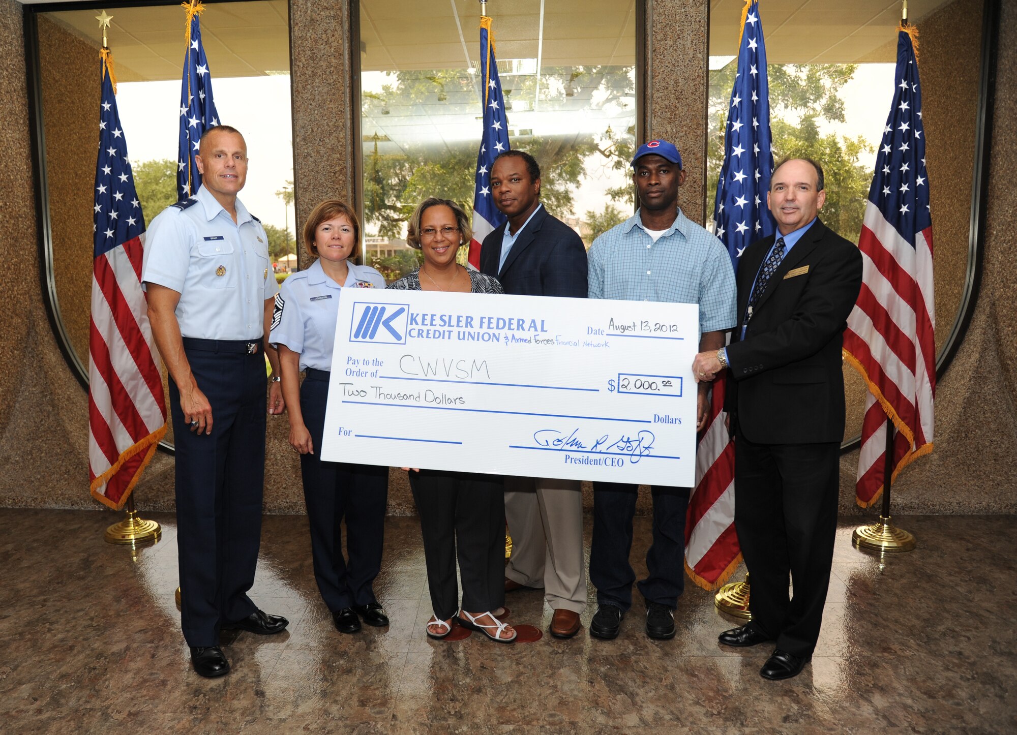Brig. Gen. Bradley Spacy, 81st Training Wing commander; Chief Master Sgt. Angelica Johnson, 81st TRW command chief; Donna Anderson, 81st Medical Group and president of the Combat Wounded Veterans of South Mississippi; Adrien Augustine, chairman of the Keesler Federal Credit Union, board of directors; Army Spc. Marlon Richards, 81st MDG and wounded warrior patient, and Gary Fulton, KFCU Larcher branch manager, pose for a photo during a check presentation  Aug. 13, 2012, to the Combat Wounded Veterans of South Mississippi, on behalf of KFCU and The Armed Forces Financial Network in the amount of $2,000 at Keesler Air Force Base, Miss. (U.S. Air Force photo by Kemberly Groue)