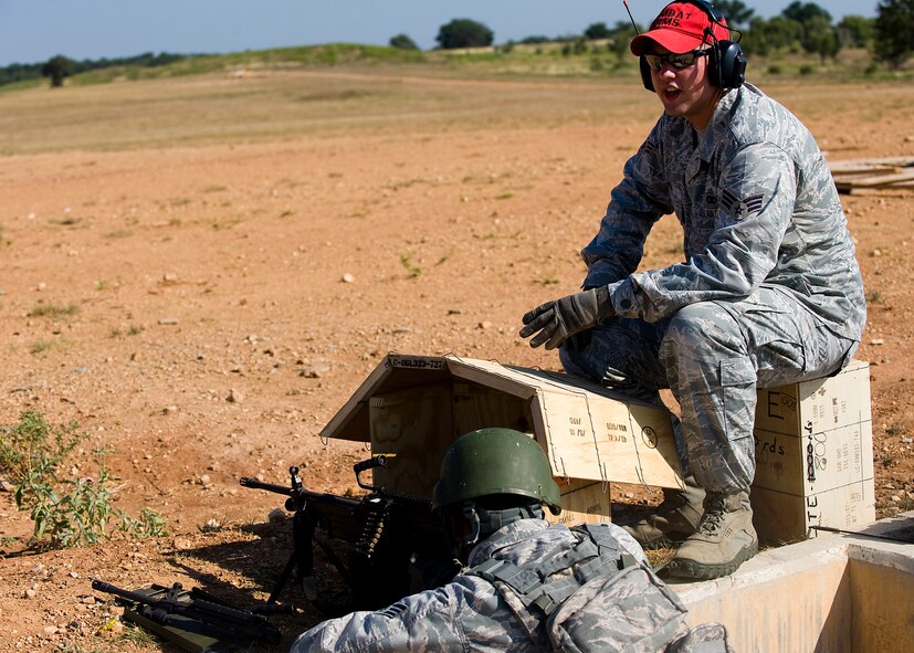 Senior Airman Matthew Smith, right, instructs Senior Airman Alexi Patterson, on firing a M249 light machine gun Aug. 10, 2012, during a heavy-weapons qualification course at Camp Bowie, Texas. While at the firing range, Airmen assigned to the 7th Security Forces Squadron shot a M249 light machine gun at targets ranging from 25 to 300 meters. The M249 allows servicemembers to place mass amount of fire on an enemy position, suppressing their movement. Prior to firing at the range, Airmen participate in a four-day classroom course, where they learn how to clean, disassemble, reassemble, operate, perform immediate actions and about different types of loads for the weapon.  (U.S. Air Force photo by Airman 1st Class Damon Kasberg/Released)