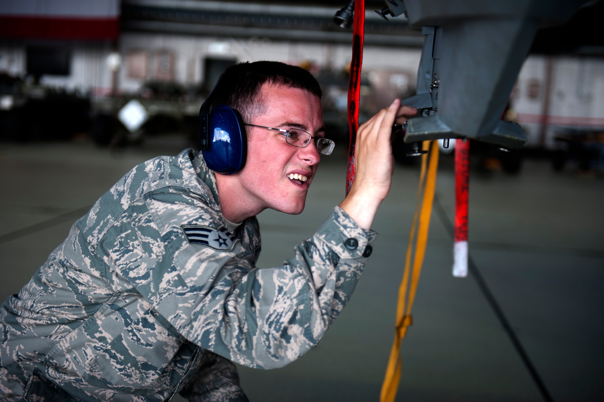 SPANGDAHLEM AIR BASE, Germany – Senior Airman Jared Schiffman, 480th Aircraft Maintenance Unit weapons load crew member, loosens a bolt in preparation to mount a Mk-82 bomb during a weapons load competition here Aug. 10.  The 480th and 81st AMUs host and participate in the timed competition once a quarter to see which unit has the fastest and most efficient weapons load crew.  The winners of the competition earn bragging rights as the best crew and a trophy until the next quarter. (U.S. Air Force photo by Airman 1st Class Gustavo Castillo/Released)