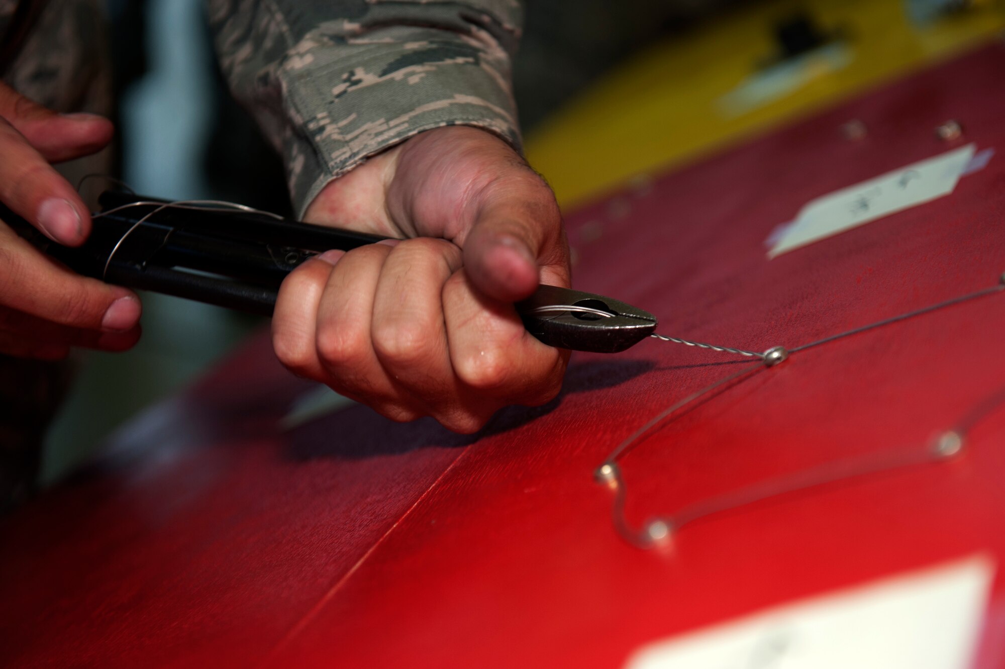SPANGDAHLEM AIR BASE, Germany – Airman 1st Class Stephen Resimius, 480th Aircraft Maintenance Unit crew chief, secures safety wire on a board during a crew chief competition here Aug. 10.  The safety wire board is used for training purposes and simulates the work maintainers may need to perform on aircraft safety wires.  A select few crew chiefs from the 480th and 81st AMUs undergo a series of mental and physical trials to test their skills and knowledge during the competition.  The winners earn bragging rights as the best maintenance unit until the next competition and also take home a wooden toolbox inscribed with the crew chief’s creed as a trophy. (U.S. Air Force photo by Airman 1st Class Gustavo Castillo/Released)