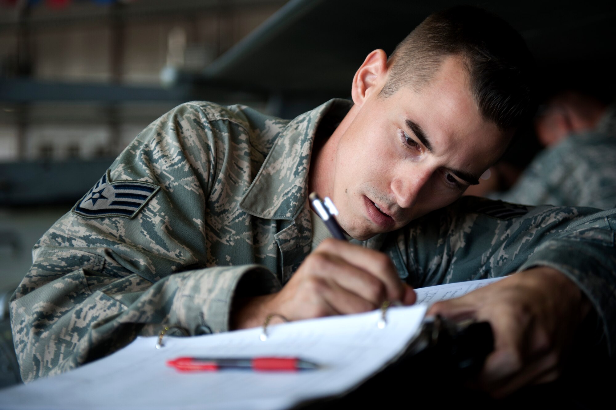 SPANGDAHLEM AIR BASE, Germany – Staff Sgt. Corey Glezen, 480th Aircraft Maintenance Unit crew chief, refers to his technical manual to determine how to attach a travel pod to an F-16 Fighting Falcon during a crew chief competition here Aug. 10. A select few crew chiefs from the 480th and 81st AMUs undergo a series of mental and physical trials to test their skills and knowledge during the competition.  The winners earn bragging rights as the best maintenance unit until the next competition and also take home a wooden toolbox inscribed with the crew chief’s creed as a trophy. (U.S. Air Force photo by Airman 1st Class Gustavo Castillo/Released)
