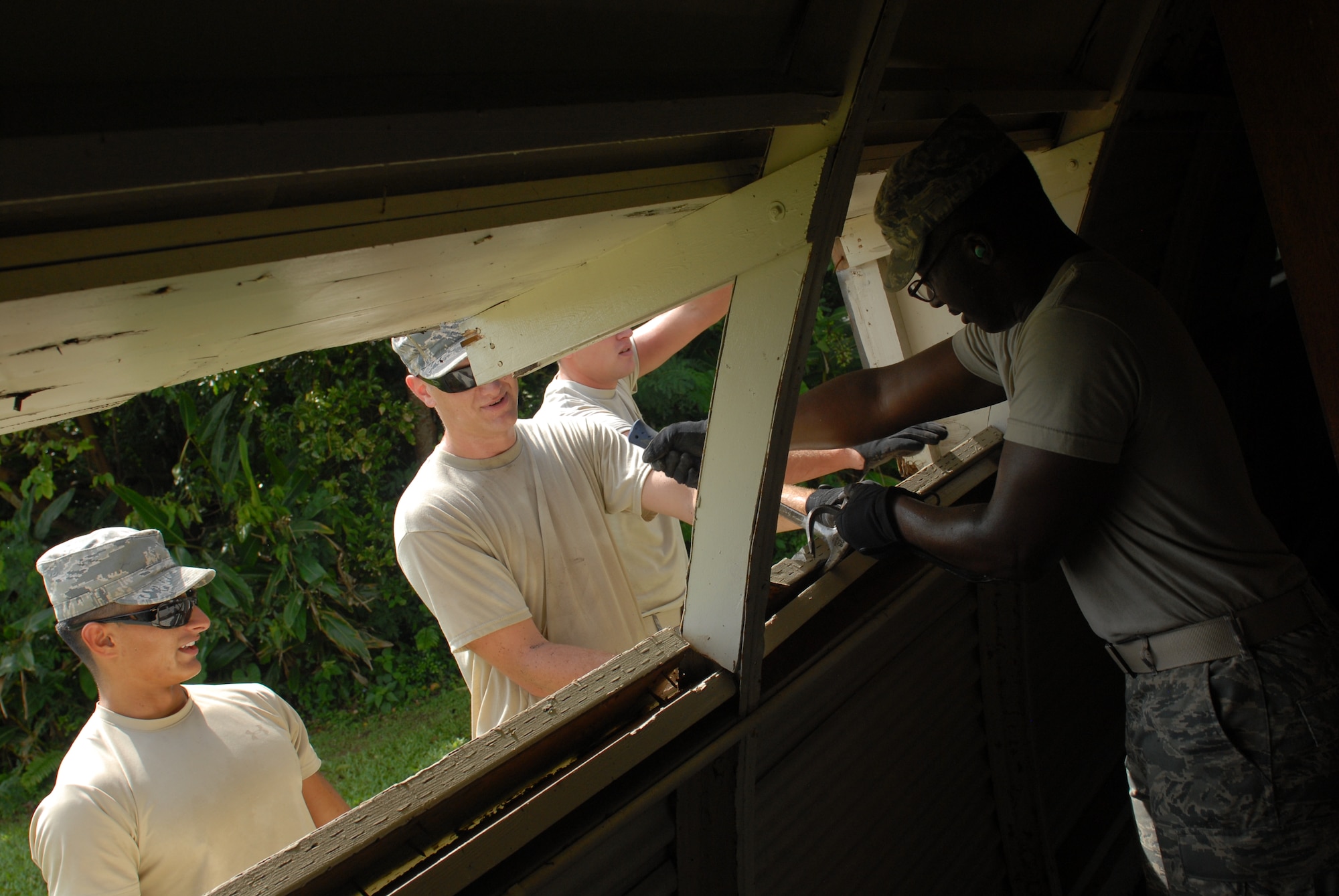 Members from the 18th Civil Engineering Squadron tear apart the window frame of a Quonset hut on Kadena Air Base, Japan, Aug. 8, 2012. The 18th CES partnered with the 18th Wing History office to restore the building as a project to help preserve the last building of its kind on Kadena. (U.S. Air Force photo/Airman 1st Class Hailey R. Davis)