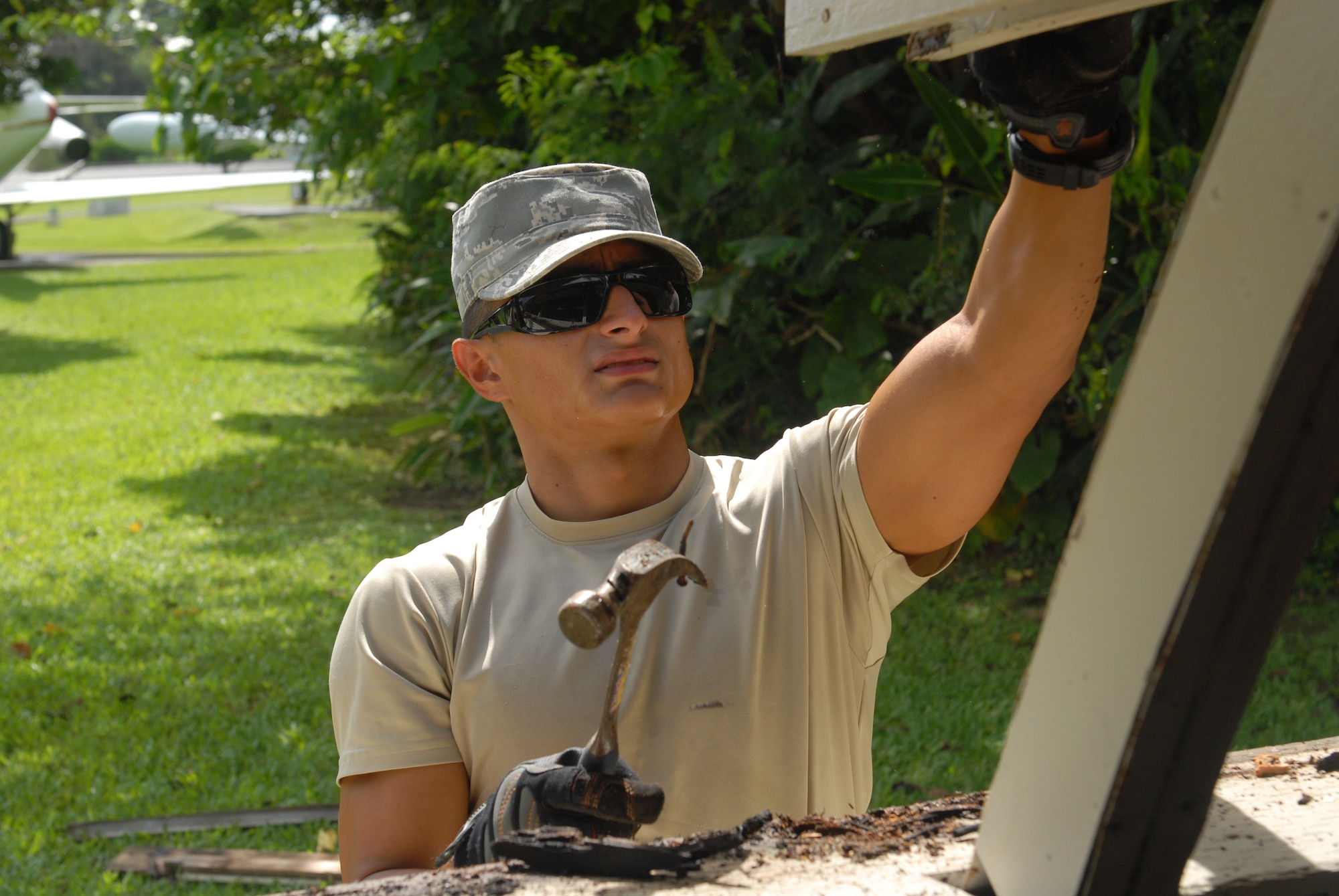 U.S. Air Force Senior Airman Christopher Almaraz, 18th Civil Engineering Squadron structural journeyman, removes rusted nails from an old window on a Quonset hut on Kadena Air Base, Japan, Aug. 8, 2012. The 18th CES partnered with the 18th Wing History office to restore the building as a project to help preserve the last building of its kind on Kadena. (U.S. Air Force photo/Airman 1st Class Hailey R. Davis)