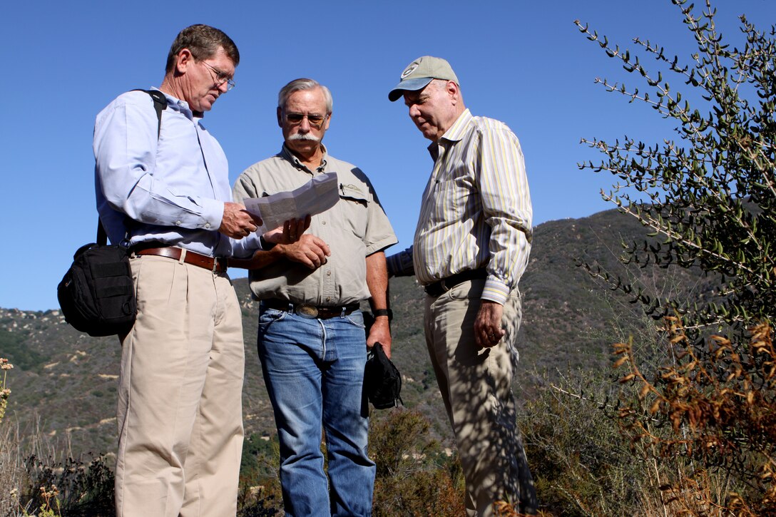 Ken Quigley, regional environmental planner, Marine Corps Base Camp Pendleton, Mike Peters, executive director, Fallbrook Land Conservancy and Robert Durling of Durling Nursery Inc. look over a map of the land obtained by the Readiness and Environmental Protection Initiative project, which closed escrow on August 14. ::r::::n::