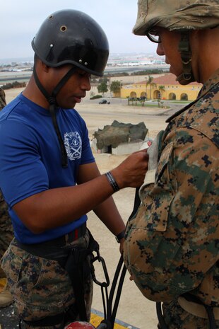 Sgt. Alanser Uruo, senior drill instructor, Platoon 3242, Company L, 3rd Recruit Training Battalion, identifies a recruit's "brake hand" before letting him rappel down the tower during recruit training aboard Marine Corps Recruit Depot San Diego Aug. 10. Drill instructors provided proper instructions to ensure the safety of their recruits and supervised them during their training.