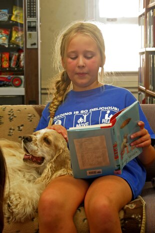 Katie Greene, 10, reads her favorite book to therapy dog, Davy, at the library Aug. 8 aboard Marine Corps Recruit Depot San Diego. "Ruff" Readers is a program developed by Independent Therapy Dogs, Inc. to help children learn to read and promote responsible pet ownership.