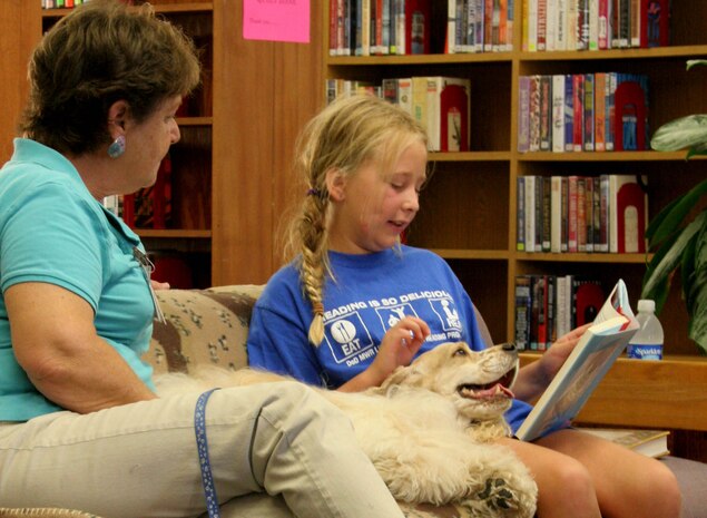 Katie Greene, 10, reads her favorite book to therapy dog, Davy, and handler Shirley Colman, founder of Independent Therapy Dogs, Inc. at the library Aug. 8 aboard Marine Corps Recruit Depot San Diego. "Ruff" Readers is a program developed by ITD, Inc. to help children learn to read and promote responsible pet ownership.