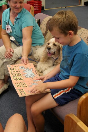 Jack Greene, 7, reads his favorite book to therapy dog, Davy, and handler Shirley Colman, founder of Independent Therapy Dogs, Inc. at the library Aug. 8 aboard Marine Corps Recruit Depot San Diego. "Ruff" Readers is a program developed by ITD, Inc. to help children learn to read and promote responsible pet ownership.
