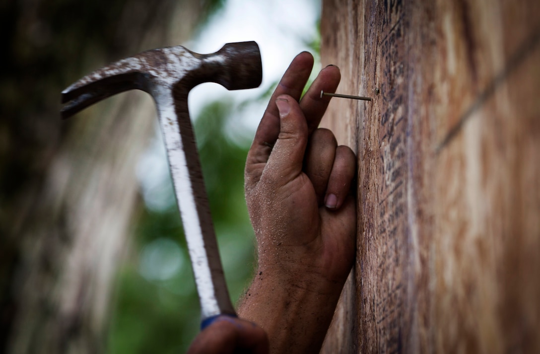 A member of the Habitat For Humanity of Boone County, Ind., hammered nails into Plywood during a house-building project for wounded Marine Sgt. Jesse James on July 26th, 2012. Habitat for Humanity joined with the Homes for Wounded Warriors Program to help build James a household prior to his return from military service.