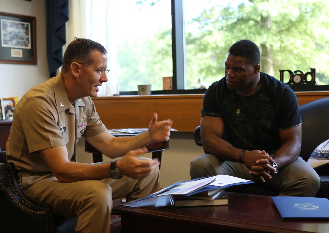 Herschel Walker talks with Navy Capt. David Lane, the commanding officer of Naval Hospital Camp Lejeune, aboard Marine Corps Base Camp Lejeune Aug. 9. Lane explains how the hospital helps service members who battle against mental health problems.