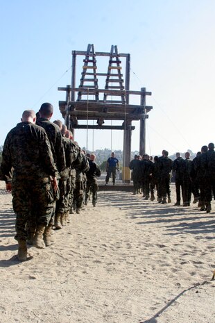 Recruits stare up at the A-Frame obstacle during the Confidence Course Aug. 14 aboard Marine Corps Recruit Depot San Diego. The A-Frame is a structure that has recruits climb a 15-foot rope, balance themselves as they walk across horizontal logs to climb up an A-shaped ladder. At that point, they are then required to climb down a 30-foot rope.