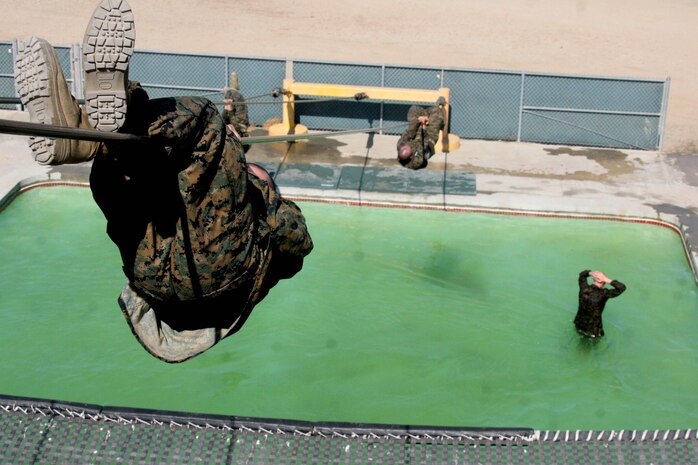 The slide for life is an obstacle that has recruits climb to the top of a 25-foot tower and climb across a descending 90-foot cable to the ground above a 4-foot deep pool. Halfway between the climb down, recruits are instructed to hang and then change posistions. If the recruit lets go, they'll fall to the water below.  