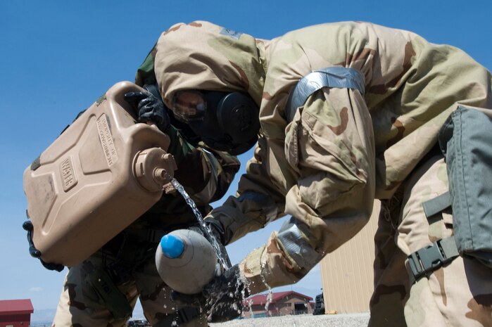 U.S. Air Force Airborne Explosive Ordnance Disposal Airmen assigned to the 820th RED HORSE clean and plug a chemical based unexploded ordnance round during a training exercise Aug. 14, 2012, at Nellis Air Force Base, Nev. The chemical round was used to improve skills. (U.S. Air Force photo by Airman 1st Class Christopher Tam)