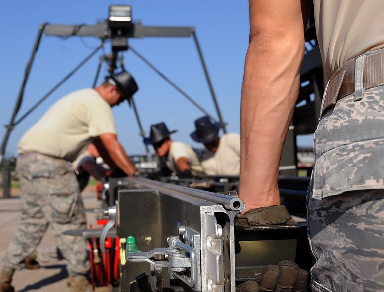 Members from the 2nd Munitions Squadron set-up a load dock to move weapons on Barksdale Air Force Base, La., Aug. 14. The 11-man ammo team is training for the upcoming annual Global Strike Challenge, hosted by Air Force Global Strike Command. Barksdale has several teams that will compete to be the best-of-the-best out of the command's operations, maintenance and security forces Airmen. (U.S. Air Force photo/Staff Sgt. Amber Ashcraft)(RELEASED) 