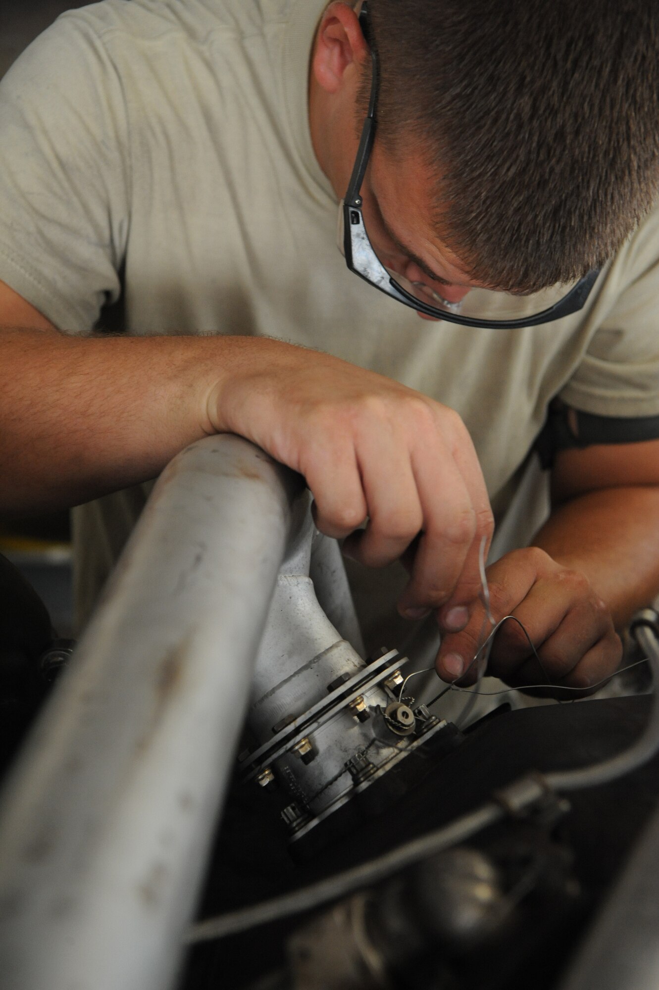 Senior Airman Colton Chandler, 2nd Maintenance Squadron aerospace propulsion craftsman, runs safety wire through a bolt connecting an air duct to an engine on Barksdale Air Force Base, La., Aug. 13. The safety wire is connected to other bolts to keep them from coming loose due to the vibrations of the engine. (U.S. Air Force photo/Airman 1st Class Micaiah Anthony)(RELEASED) 