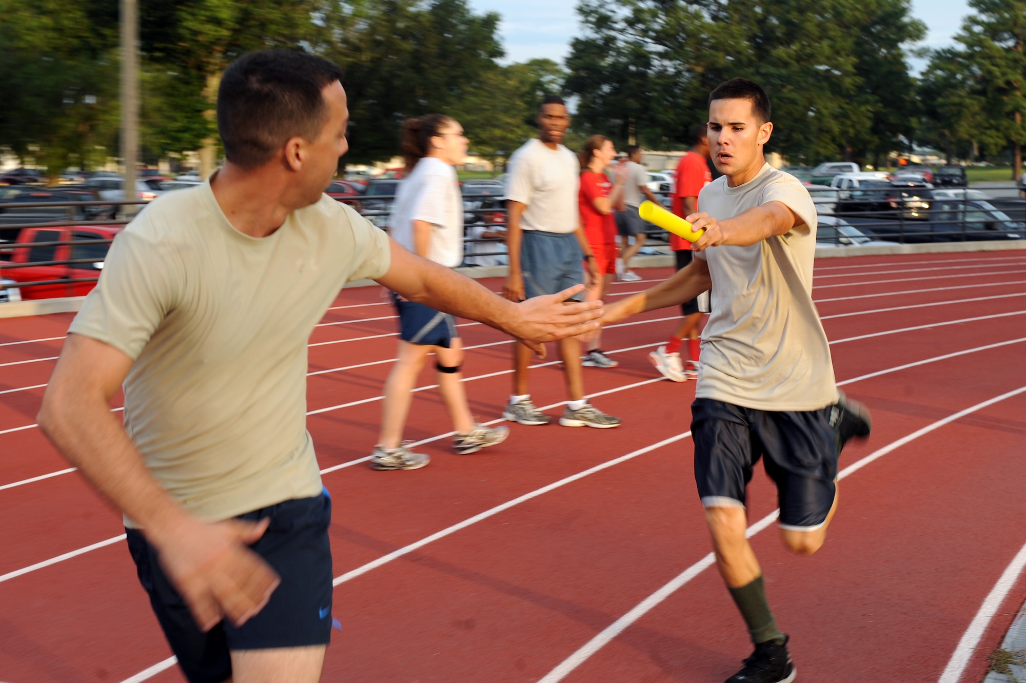U.S. Air Force Tech. Sgt. Brian Knispel, 482nd Aircraft Maintenance Squadron aircraft electrician from Homestead Air Reserve Base, Fla., reaches out for a baton Senior Airman Christian Marrero-Santana, 482nd AMXS aircraft armament technician also from Homestead, during the Beat the Heat relay run at Seymour Johnson Air Force Base, N.C., Aug. 10, 2012. The 482nd AMXS team finished first with a time of 5:27. (U.S. Air Force photo/Airman 1st Class John Nieves Camacho/Released)