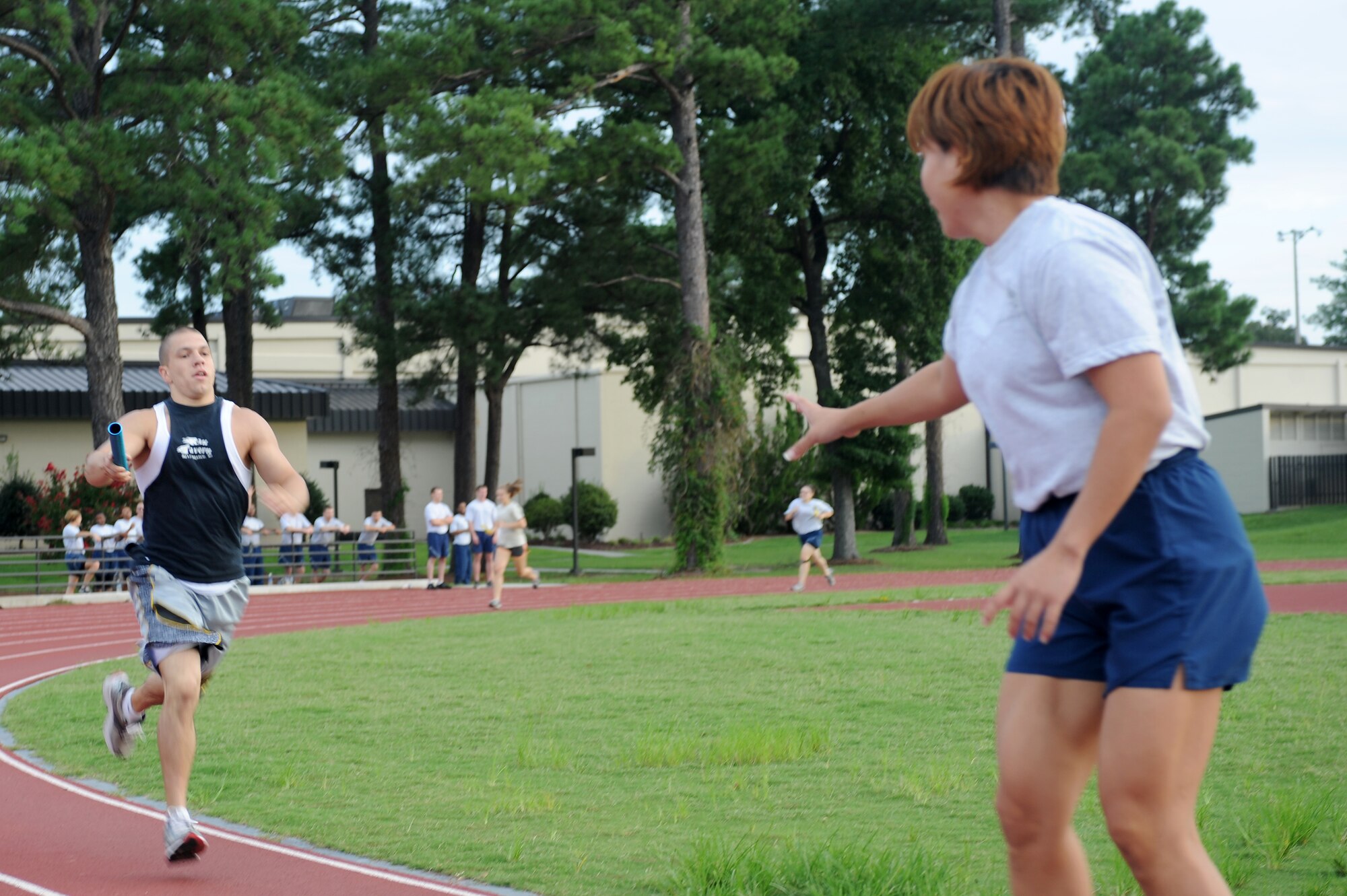 U.S. Air Force Airman 1st Class Mike Kavalunas, 4th Force Support Squadron services apprentice, sprints to hand off a baton to Tech. Sgt. Maria Taylor, 4th FSS dining facility assistant manager, during the Beat the Heat relay run at Seymour Johnson Air Force Base, N.C., Aug. 10, 2012. The 4th FSS team finished fourth with a run time of 6:01. (U.S. Air Force photo/Airman 1st Class John Nieves Camacho/Released)