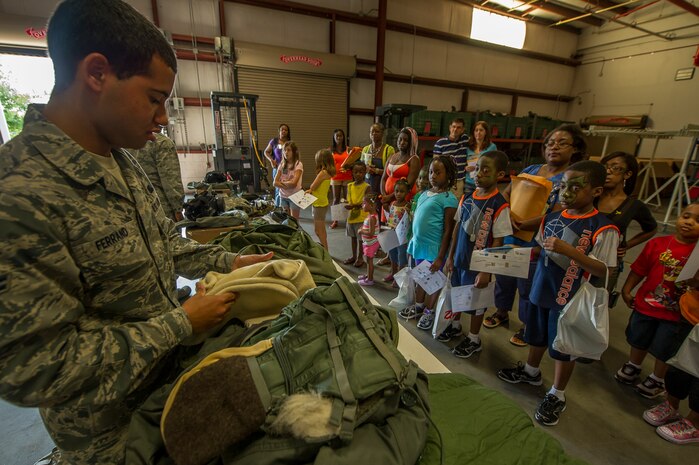 Airman 1st Class Christopher Ferrand, 628th Logistics Readiness Squadron individual protective equipment journeyman, shows a mobility bag and its contents to participants of the Children's Deployment Camp, Aug. 14, 2012, at Joint Base Charleston – Air Base, S.C. The Children’s Deployment Camp, hosted by the Airman and Family Readiness Center, offered children, age five to 14 whose parents have recently returned from deployment, are currently deployed or are scheduled to deploy within the next six months, the opportunity to experience many of the same things their parents have to go through to prepare for a deployment. (U.S. Air Force photo by Airman 1st Class George Goslin)