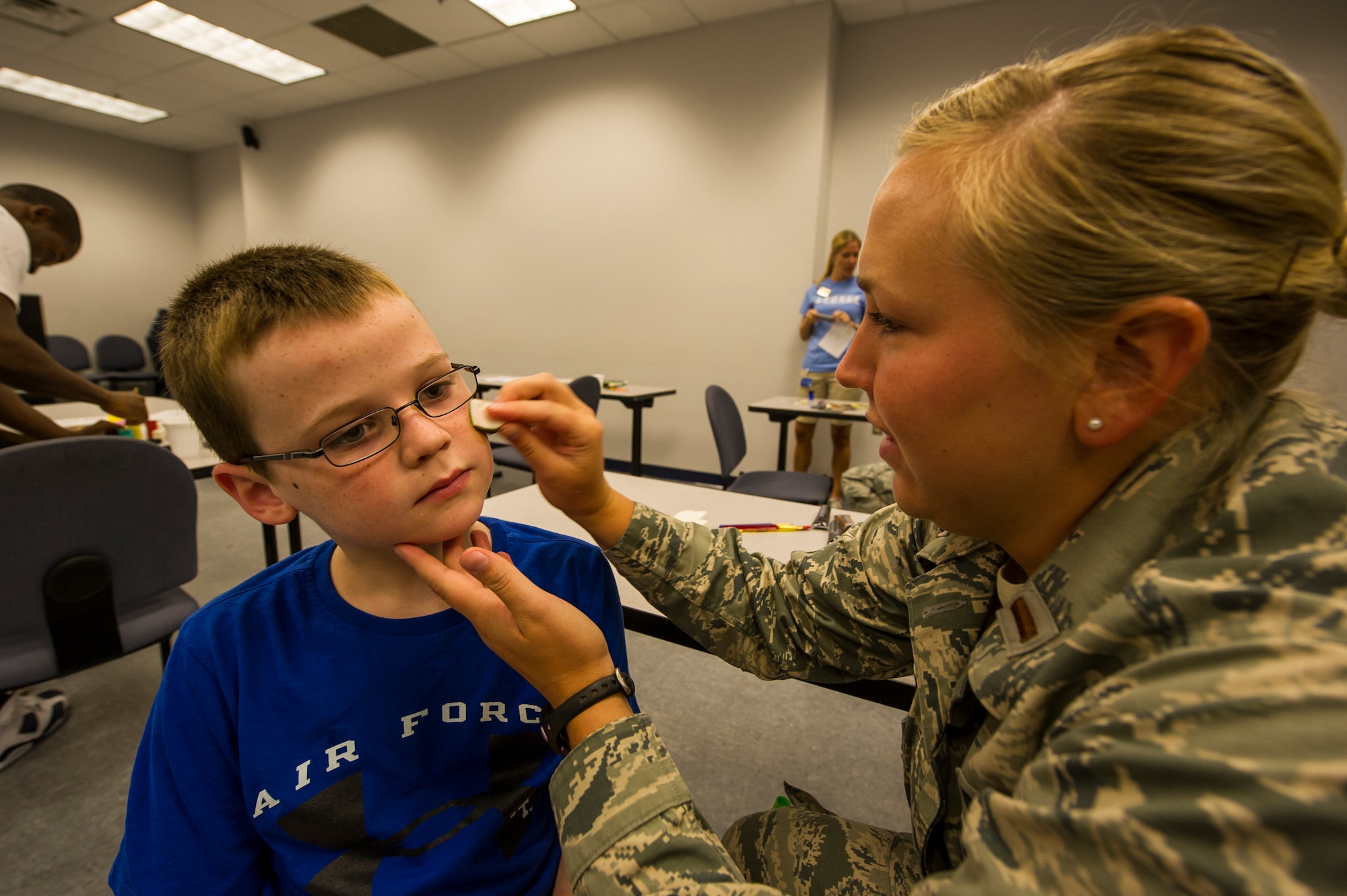 2nd Lt. Andrea Gehrman, 437th Aircraft Maintenance Squadron assistant aircraft maintenance unit officer-in-charge, applies face paint to Dalton Perry, step-son of Tech. Sgt. David Leininger, 437th Operations Support Squadron intelligence analyst, during the Children's Deployment Camp, Aug. 14, 2012, at Joint Base Charleston - Air Base, S.C. The Children’s Deployment Camp, hosted by the Airman and Family Readiness Center, offered children, age five to 14 whose parents have recently returned from deployment, are currently deployed or are scheduled to deploy within the next six months, the opportunity to experience many of the same things their parents have to go through to prepare for a deployment. (U.S. Air Force photo by Airman 1st Class George Goslin)