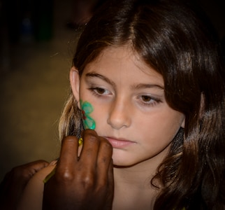 Taylor Kolbe, daughter of 437th Aerial Port Squadron load planner Tech. Sgt. Robert Kolbe, gets her face painted by Staff Sgt. Carey Grant, 628th Civil Engineer Squadron electrical system journeyman, during the Children’s Deployment Camp, August 14, at Joint Base Charleston – Air Base, S.C. The Children’s Deployment Camp, hosted by the Airman and Family Readiness Center, offered children, age five to 14 whose parents have recently returned from deployment, are currently deployed or are scheduled to deploy within the next six months, the opportunity to experience many of the same things their parents have to go through to prepare for a deployment. (U.S. Air Force photo by Senior Airman Anthony Hyatt)