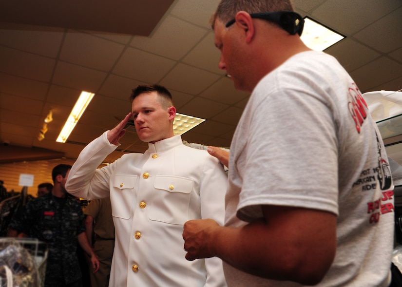 Electronics Technician First Class Petty Officer Sean McKenzie, Nuclear Power Training Unit and chief petty officer selectee, tries on a Navy service dress white uniform, commonly referred to as choker whites August 14, 2012, at the uniform shop at Joint Base Charleston - Weapons Station, S.C., while Master-at-Arms Chief Petty Officer Marvin McDonald, NPTU, ensures he has the proper fit. Selection for promotion to chief petty officer requires selectees to purchase a new "sea bag," which consists of new khaki and service dress uniforms. (U.S. Air Force photo/ Airman 1st Class Chacarra Walker)