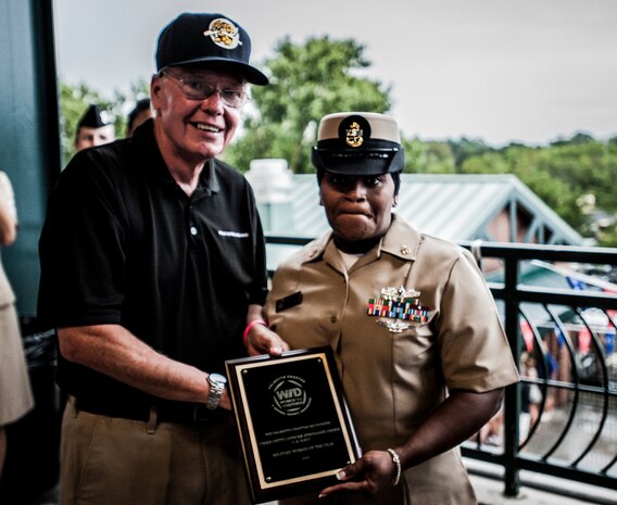 U.S. Navy Chief Petty Officer Stephanie Green, Naval Brig Charleston Parole and Release department leading chief petty officer, is awarded the Palmetto Chapter of Women in Defense, Military Woman of the Year plaque from Phil Lacombe, event sponsor, at the Charleston RiverDogs game Aug. 11 in Charleston, S.C. Green was one of 15 military women nominated for the award. (U.S. Air Force photo by Senior Airman Dennis Sloan)