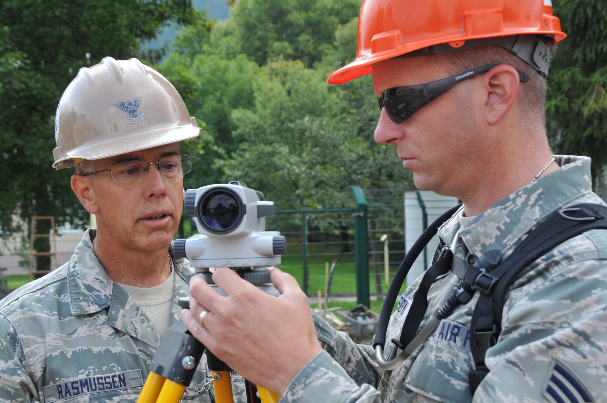 Staff Sgt. Tom Rasmussen, 153rd Civil Engineer Squadron engineering assistant, teaches Senior Airman Joel Johnson, engineering assistant in training, how to take measurements using a self-leveling level, Aug. 13, 2012, at the NATO School, Oberammergau, Germany. Airmen from the 153rd CES are putting their skills to work as they conduct their annual training. (U.S. Air Force photo by Staff Sgt. Natalie Stanley)