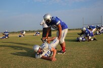Daniel Grape (top) and Ceasar Romero, Joint Base San Antonio-Randolph High School football players help each other stretch before early morning practice Aug. 13. The football team started summer practice  Aug 6. (U.S. Air Force photo by Rich McFadden) 