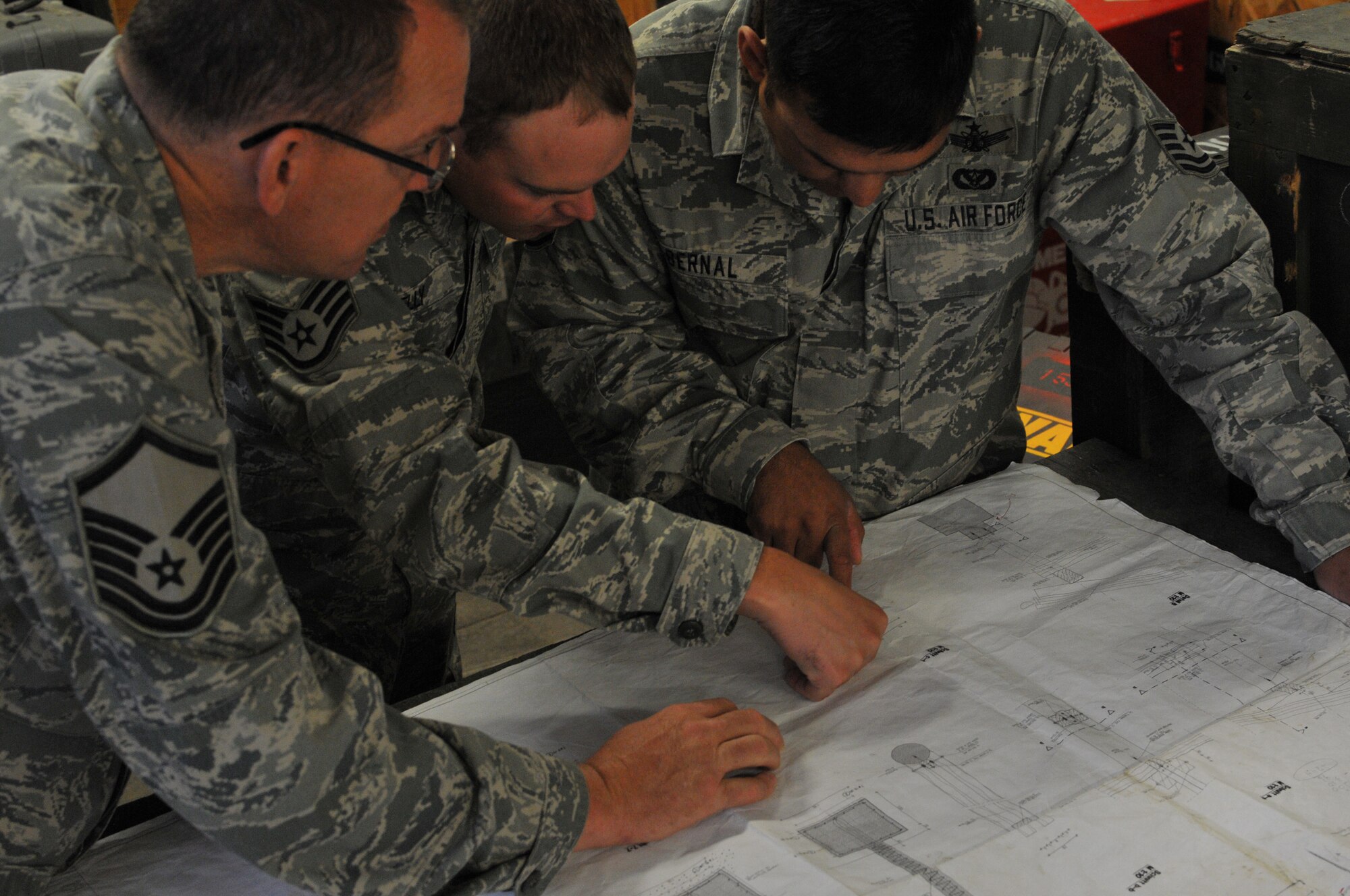 Wyoming Air National Guard members Master Sgt. Andy Kelso, Staff Sgt. Joshua Kelly, and Tech. Sgt. Mike Bernal, 153rd Civil Engineer Squadron structures workers, review blueprints for the NATO School recreation center car port Aug. 13, 2012, Oberammergau, Germany. Airmen from the 153rd CES are putting their skills to work as they conduct their annual training. (U.S. Air Force photo by Staff Sgt. Natalie Stanley)