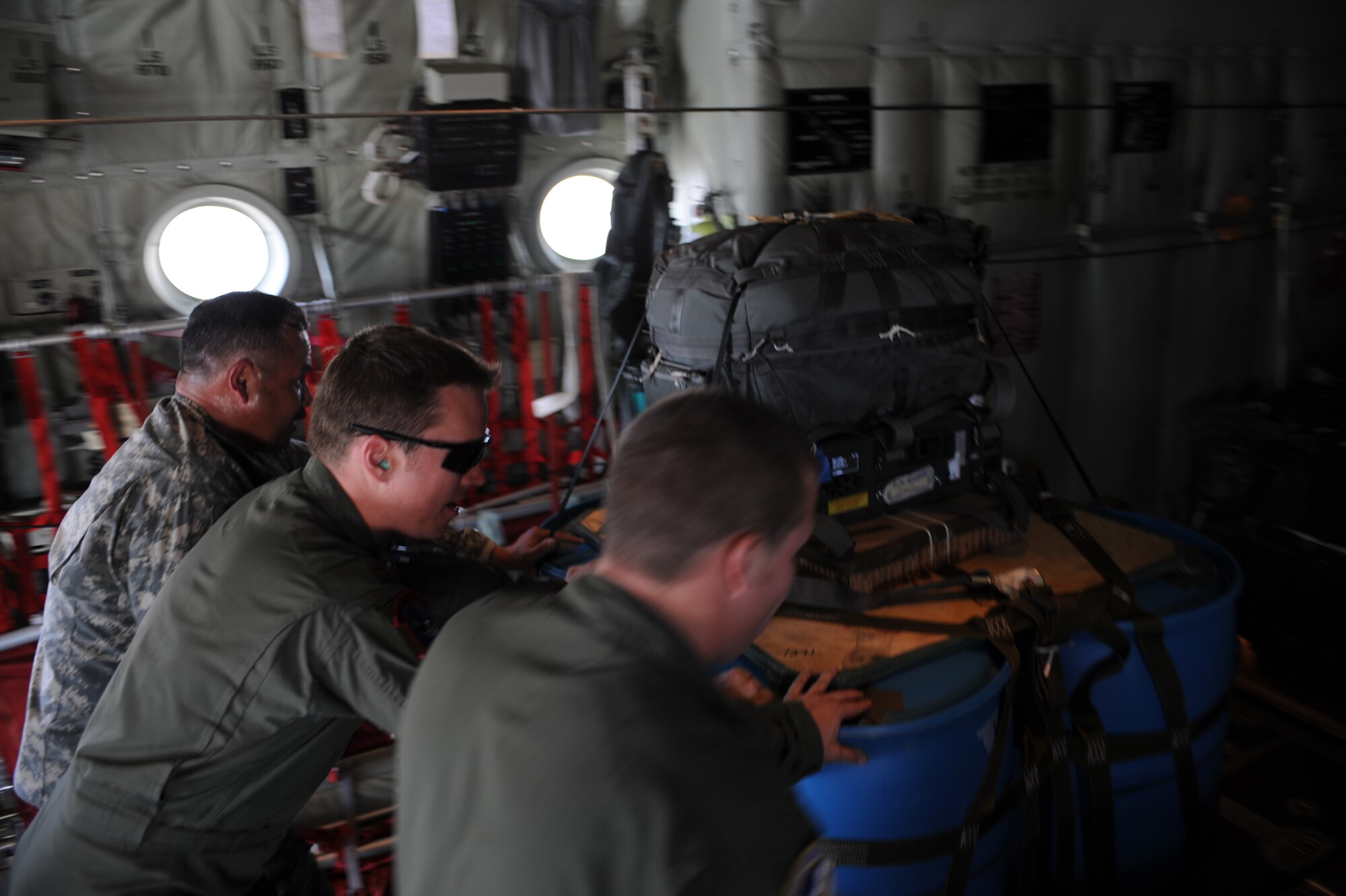 U.S. Army Sgt. 1st Class Ray Mendez, 294th Quartermaster Company, left, U.S. Air Force Maj. Daniel Hilferty, 317th Operations Support Squadron, center, and U.S. Air Force Staff Sgt. Mark Paskell, 40th Airlift Squadron, right, push a cargo bundle equipped with a Joint Precision Airdrop System (JPADS) onto a C-130J Super Hercules assigned to the 317th Airlift Group prior to an airdrop training mission Aug. 14, 2012, at Fort Hood, Texas.  JPADS is a cargo parachute system that incorporates an onboard global positioning system able to guide the cargo with pinpoint accuracy to a designated drop zone. JPADS also allows cargo to be dropped from higher attitudes, allowing aircraft to safely avoid enemy ground fire. (U.S. Air Force photo by Staff Sgt. Richard P. Ebensberger/ Released)