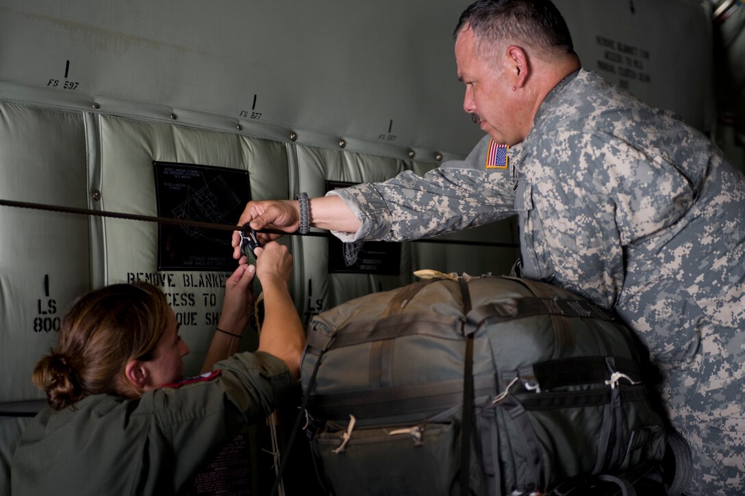 U.S. Air Force Staff Sgt. Janet Freshley, 317th Operations Support Squadron, left, and U.S. Army Sgt. 1st Class Ray Mendez, 294th Quartermaster Company, connect an activation lanyard from a cargo parachute equipped with Joint Precision Airdrop System (JPADS) to a C-130J Super Hercules assigned to the 317th Airlift Group, prior to an airdrop training mission Aug. 14, 2012, at Fort Hood, Texas.  JPADS is a cargo parachute system that incorporates an onboard global positioning system able to guide the cargo with pinpoint accuracy to a designated drop zone. JPADS also allows cargo to be dropped from higher attitudes, allowing aircraft to safely avoid enemy ground fire. (U.S. Air Force photo by Staff Sgt. Richard P. Ebensberger/ Released)