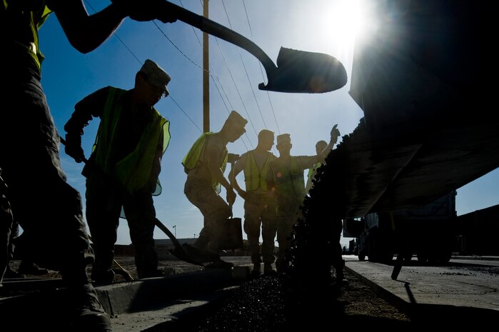 U.S. Air Force Airmen from the 99th Civil Engineer Squadron lay asphalt for a new sidewalk alongside the construction of a  new parking lot Aug. 15, 2012, at Nellis Air Force Base, Nev. The parking lot and sidewalk construction will improve parking for work centers. (U.S. Air Force photo by Airman 1st Class Daniel Hughes)