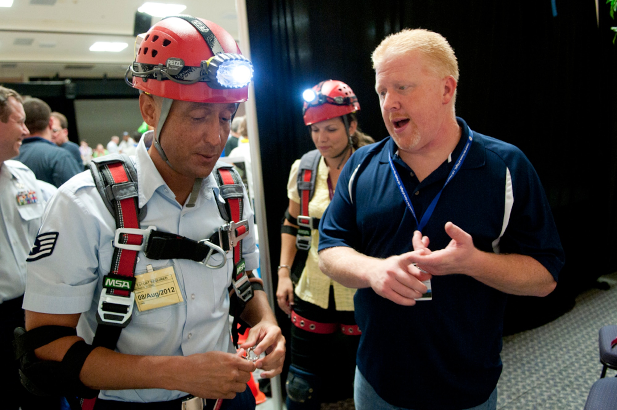 LYNN, Mass. -- Staff Sgt. Michael Mavrakis (left) receives instruction from Chuck Cashman, General Electric maintenance construction, before a simulated confined space rescue operation at a health and wellness fair at the plant Aug. 8. Several members from the Hanscom community traveled here to attend the Voluntary Protection Program inspired fair hosted by GE employees. (U.S. Air Force photo by Mark Wyatt)