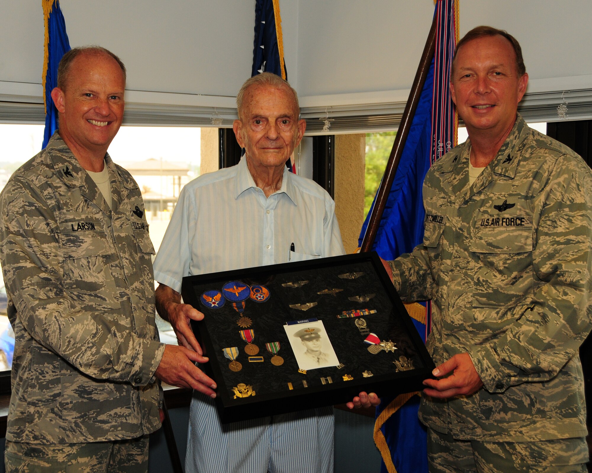 Lt.Col. (retired) Dick Waring displays a shadow box with his rank and medals with Col. Allan Swartzmiller (right), 914th Airlift Wing Commander and Col. Bret Larson (left), 914th Airlift Wing Vice Commander at the Niagara Falls Air Reserve Station, NY on August 4, 2012. Waring was presented with the shadow box in appreciation for telling his story for the Air Force Pioneers in Blue Program, to be seen in the near future on the internet. (U.S. Air Force photo by Peter Borys)