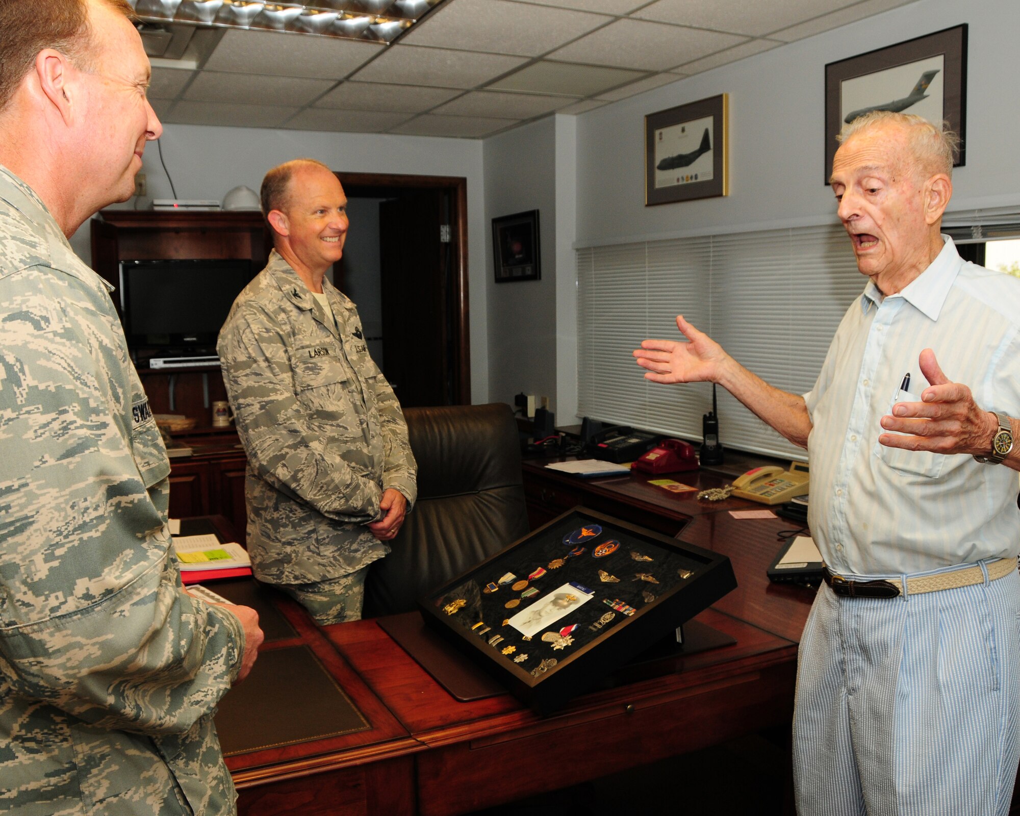 Lt.Col. (retired) Dick Waring  shares an amusing story from one of his combat missions over Germany as a B-17 navigator during WWII  with Col. Allan Swartzmiller (left) 914th Airlift Wing Commander and Col. Bret Larson, 914th Airlift Wing Vice Commander at the Niagara Falls Air Reserve Station, NY on August 4, 2012. Waring was presented with a shadow box of his rank and medals in appreciation for telling his story for the Air Force Pioneers in Blue Program, to be seen in the near future on the internet. (U.S. Air Force photo by Peter Borys)