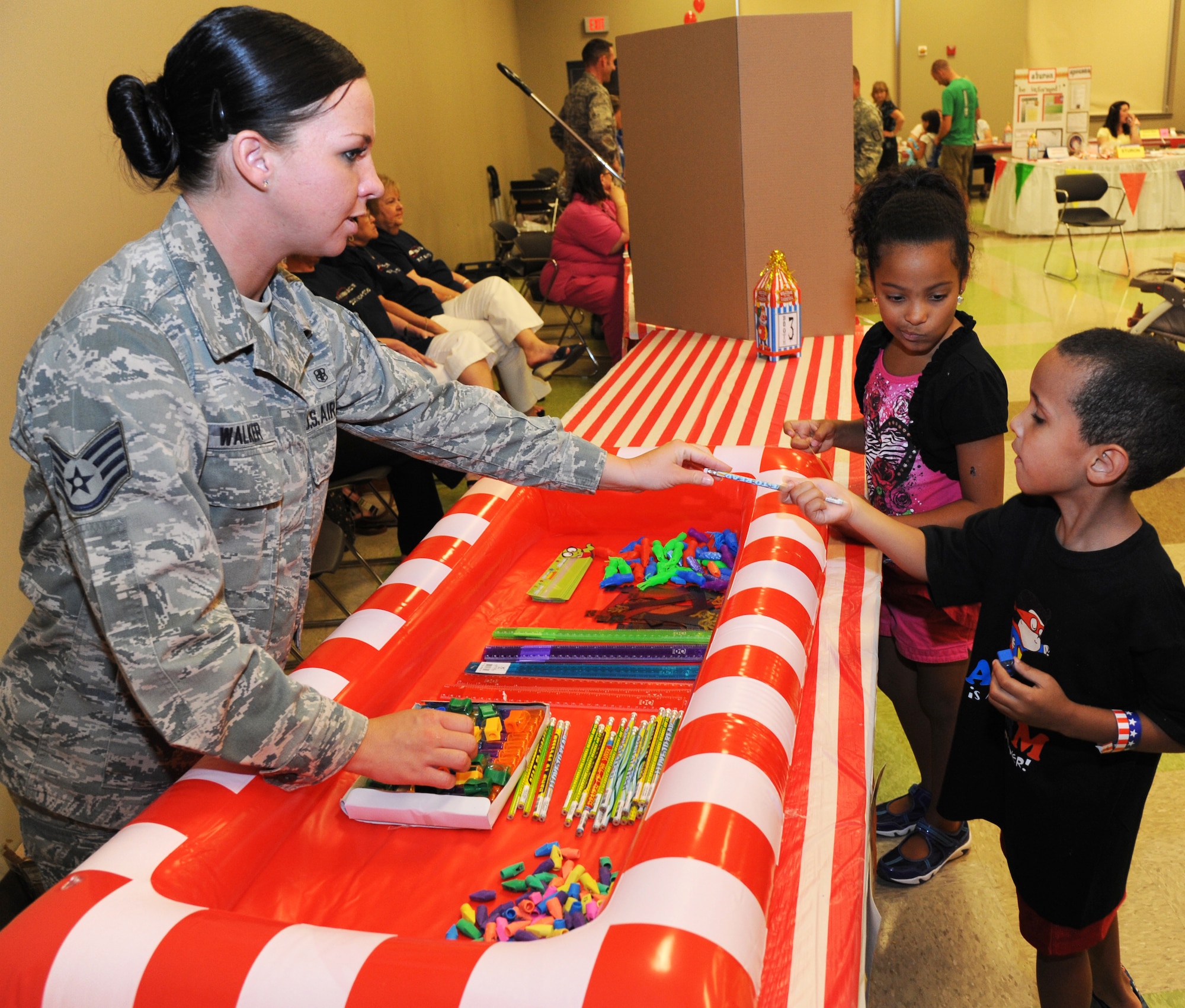 Staff Sgt. Holly Walker, NCO in charge of records and reception with the 71st Medical Operations Squadron, hands out pencils during the Back to School Bash in the Armed Forces Reserve Center at Vance Air Force Base, Okla., Aug. 10. (U.S. Air Force photo/ Airman 1st Class Frank Casciotta)