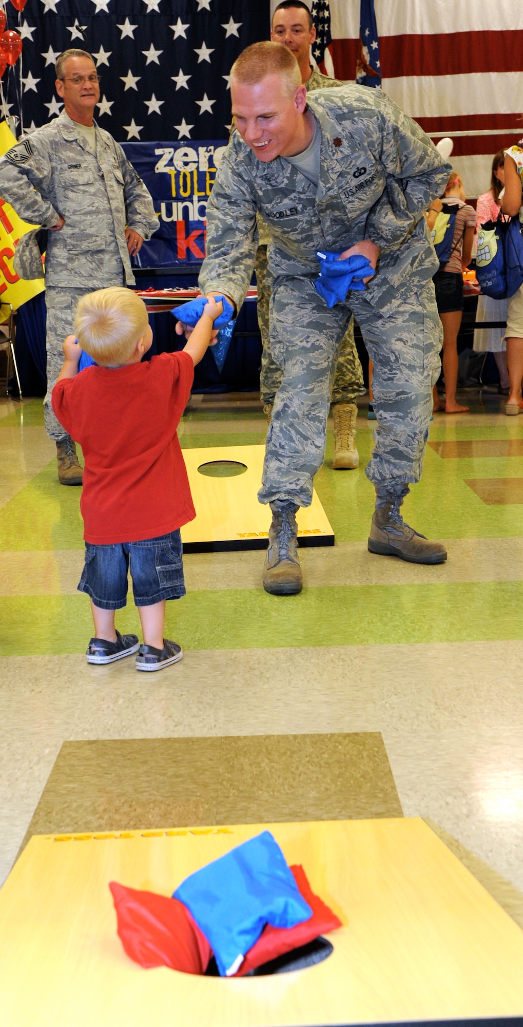 Maj. David Woodley, with the 71st Operations Support Squadron, plays a beanbag toss game with children at the Back to School Bash at Vance Air Force Base, Okla., Aug. 10.  (U.S. Air Force photo/ Airman 1st Class Frank Casciotta)