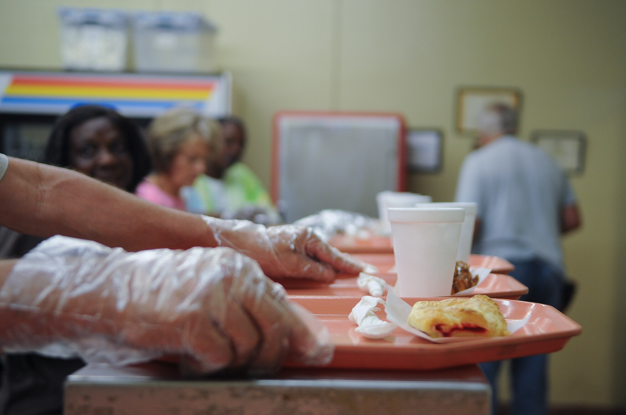 A volunteer at the Community Soup Kitchen passes a serving tray down to the next section during lunch in Valdosta, Ga., Aug. 14, 2012. The Community Soup Kitchen is open 5 days a week and is willing to feed anyone who comes through the door. (U.S. Air Force photo by Airman 1st Class Olivia Dominique/Released)