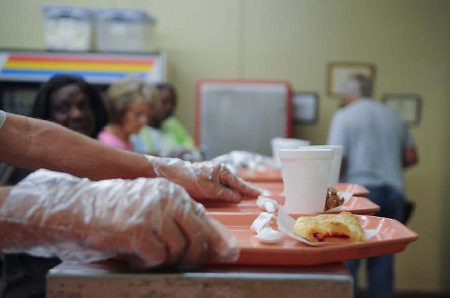 A volunteer at the Community Soup Kitchen passes a serving tray down to the next section during lunch in Valdosta, Ga., Aug. 14, 2012. The Community Soup Kitchen is open 5 days a week and is willing to feed anyone who comes through the door. (U.S. Air Force photo by Airman 1st Class Olivia Dominique/Released)