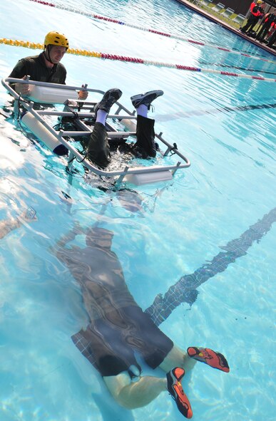 An aircrew member attending the water survival training course is upside down in the Shallow Water Egress Trainer (SWET) chair at Moody Air Force Base, Ga., Aug. 9, 2012. The SWET chair tests the aircrew member’s ability to breathe using a helicopter emergency egress device and successfully get out of the seatbelt while being underwater. (U.S. Air Force photo by Staff Sgt. Stephanie Mancha/Released)
