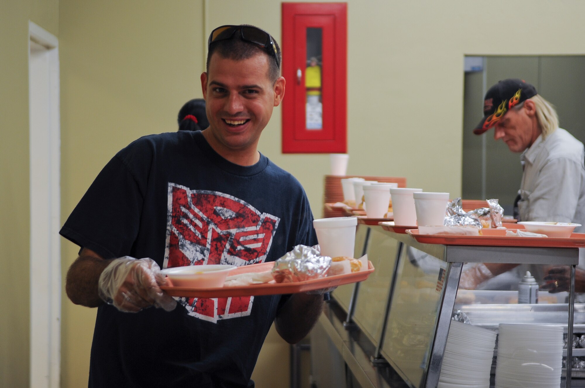 U.S. Air Force Staff Sgt. Eric Neumeier, member of the Moody Air Force Base Chapter 460 Air Force Sergeants Association, poses with a serving tray while volunteering at the Community Soup Kitchen in Valdosta, Ga., Aug. 14, 2012. Members of AFSA volunteered to give back to the local community by helping out in a soup kitchen. (U.S. Air Force photo by Airman 1st Class Olivia Dominique/RELEASED)