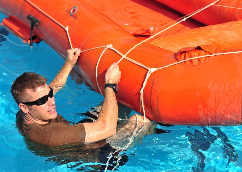 U.S. Air Force Tech. Sgt. Daniel Daubert, 347th Operations Support Squadron survival evasion resistance and escape specialist, teaches aircrew members how to properly board a life raft during the water survival training course at Moody Air Force Base, Ga., Aug. 9, 2012. Members learn how to escape a canopy, disconnect a parachute during high winds and various other survival techniques.
 (U.S. Air Force photo by Staff Sgt. Stephanie Mancha/Released)
