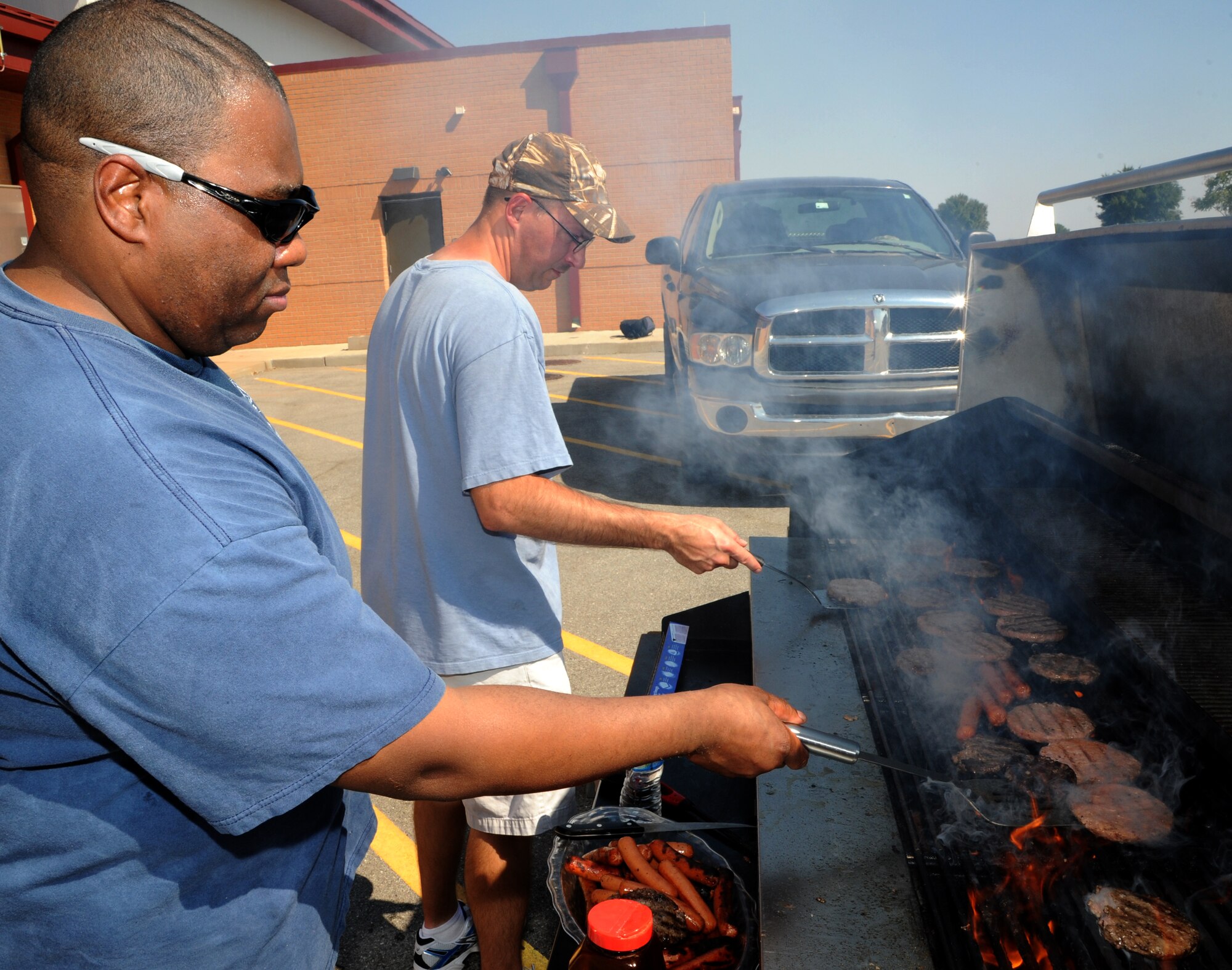 Master Sgt. Michael Carradine, left, and Senior Master Sgt. Jay Hoth flip burgers during the Top 3 Burger Burn held at the Armed Forces Reserve Center, Vance Air Force Base, Okla., Aug. 13. Carradine is the acting first sergeant for the 71st Mission Support Group. Hoth is the 71st Force Support Squadron superintendent. (U.S. Air Force photo/ Airman 1st Class Frank Casciotta)
